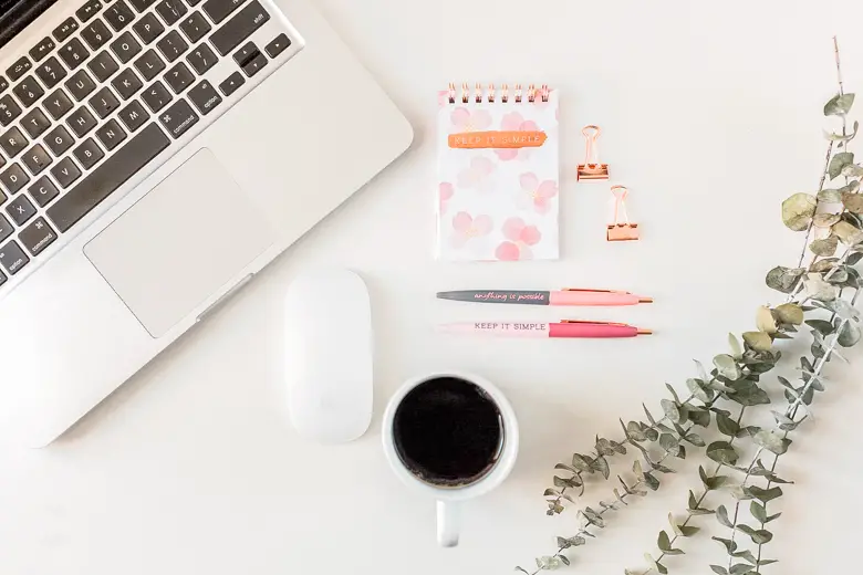 Aerial view of stationery, cup of coffee, laptop, and some greenery - my first blogiversary, 7 things I wish I knew before starting a blog