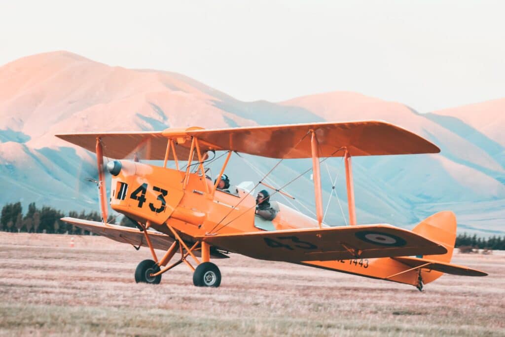 small plane with mountains in the background - UK travel apps for booking flights
