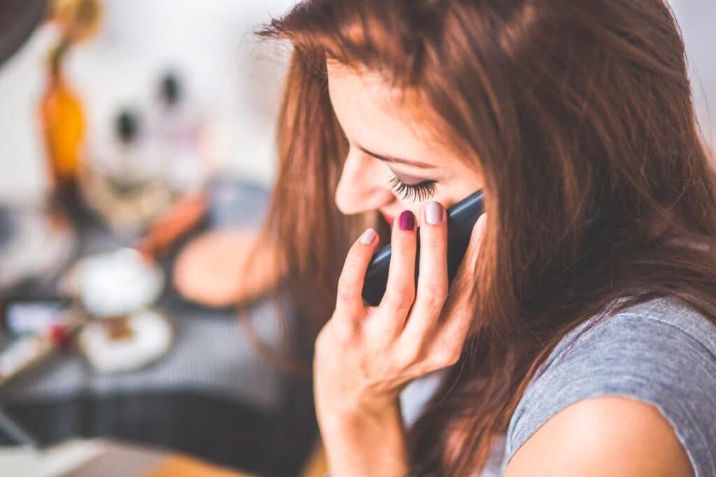 woman talking on the phone - UK travel apps for staying in touch with others